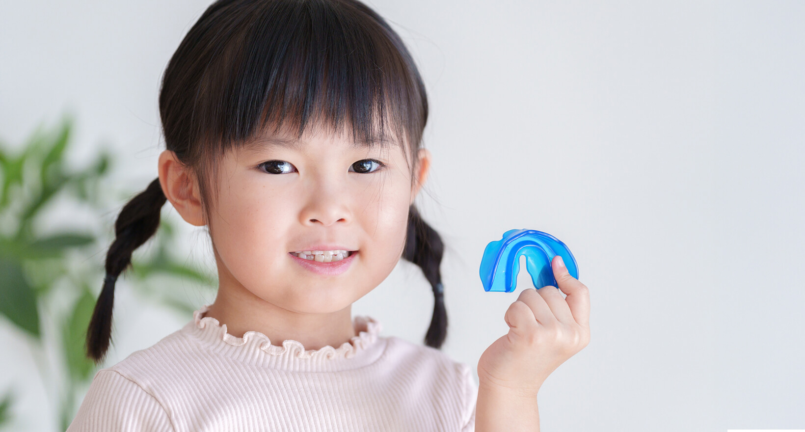 マウスピース型矯正装置を持つ子供